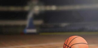 A basketball resting on a wooden court