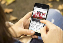 Startling Officer HOAX — Trooper On TRIAL Person holding smartphone displaying fake news notification.