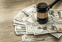 Gavel on a pile of hundred-dollar bills.