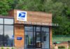 Exterior view of a modern United States Post Office building surrounded by greenery
