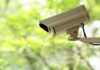 Masked Trio Terrorizes Widow—Doorbell Camera Captures It All A security camera mounted outdoors with a blurred green background