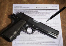 Gun and pen on firearm transaction form.