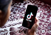 Hand holding phone showing TikTok logo
