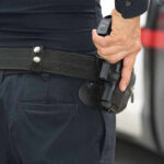 LAPD Officers AMBUSHED With 12-Inch Blade Person holding a gun in a holster.