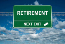 Green road sign reading retirement next exit sky background