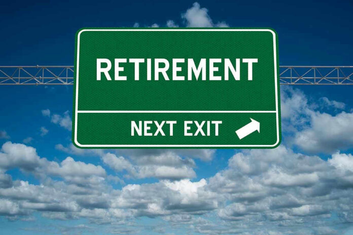 Green road sign reading retirement next exit sky background