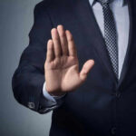 Trump HALTS Third World Migration – MASSIVE Shift Begins Man in suit with hand raised, signaling stop.