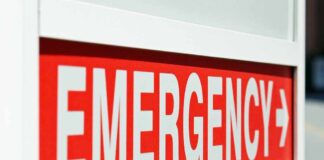 Emergency sign indicating direction with a red background and white text