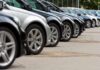 A row of parked black and silver cars in a dealership