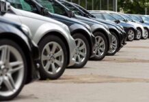 A row of parked black and silver cars in a dealership