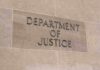 Sign displaying 'Department of Justice' on a stone wall