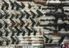 Wall display with handguns and rifles for sale.