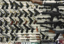 Wall display with handguns and rifles for sale.