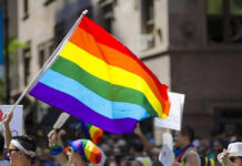 Seattle’s Pride Event Invited Teams Who’s Countries Prosecuted Gays! People holding and waving a rainbow flag.