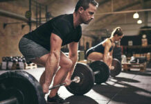 World’s Strongest Woman Title Sparks Gender Identity Uproar Man and woman lifting barbells in gym.