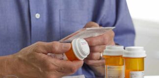Person holding a prescription bottle and reading medical instructions