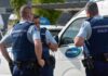 Terrorist Tackled: Fruit Seller’s Daring Act Three police officers discussing near a police vehicle