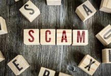 Scam Call Epidemic: Is Your Phone Safe? Wooden blocks spell SCAM on a rustic surface.