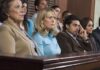 A group of jury members sitting in a courtroom with serious expressions