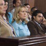 A group of jury members sitting in a courtroom with serious expressions