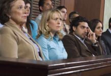 A group of jury members sitting in a courtroom with serious expressions