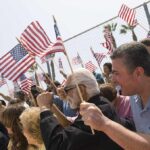 A diverse crowd holding American flags during a patriotic event