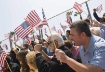 Americans Reject War: Shocking Poll A diverse crowd holding American flags during a patriotic event
