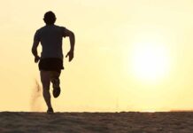 Silhouette of a man running on the beach during sunset