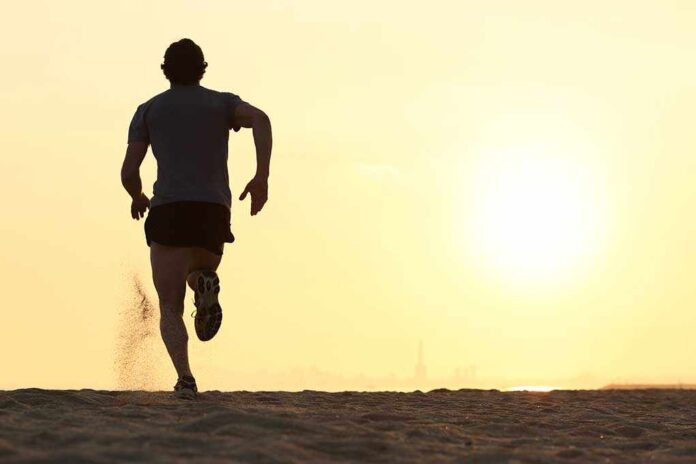 Silhouette of a man running on the beach during sunset