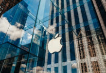 Apple store with glass facade and city reflections.