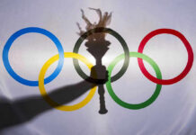 Miracle Repeat STUNS Canada — Then THIS Happened Shadow of torch over Olympic rings logo.
