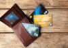 Wallet with three credit cards on wooden surface