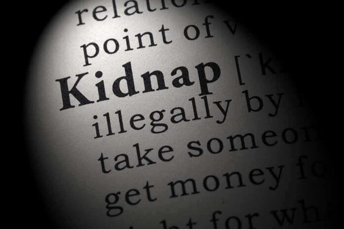 Close-up of a dictionary page showing the definition of the word 'kidnap'