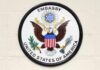 Seal of the United States Embassy featuring an eagle and the American flag