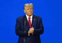 Man in a suit with a blue background.