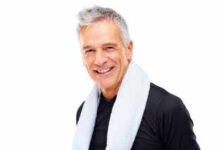 Smiling older man wearing a black shirt with a towel around his neck