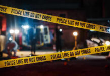 Supermarket Run Turns Into Warzone – Officer KILLED! Yellow police tape in front of crime scene.