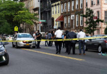 Car Explosion Shreds Quaint Neighborhood Street Police gathered at an urban crime scene.