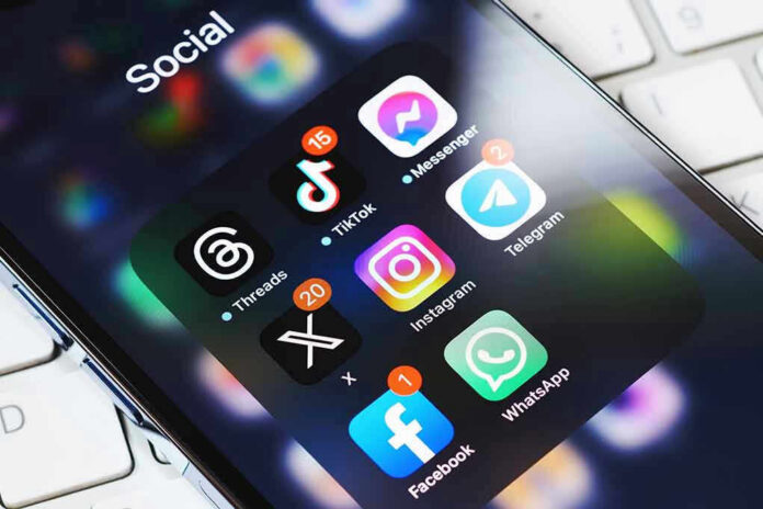 2339442245 Smartphone showing social media app icons in a folder.