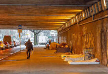 Mamdani Offers Pathetic Excuse For Growing Tent City People walk under a bridge with homeless encampment.