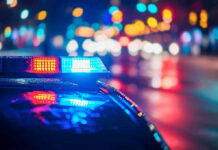 Teen ARRESTED – Chilling Terror Plot Shocks City! Police car with flashing lights at night.