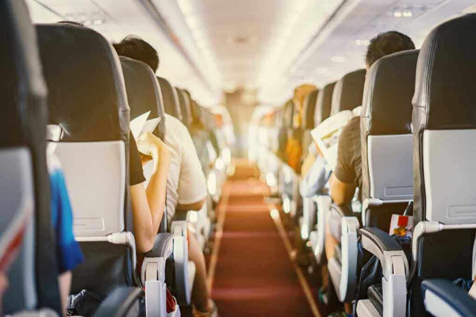626651186 Passengers seated inside an airplane cabin.