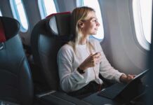 Passenger with headphones seated by airplane window