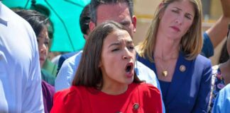 Woman in red dress speaking passionately at outdoor press conference