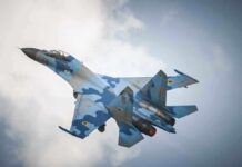 Trump Considers Selling F-35 to Muslim Country A blue camouflage fighter jet performing an aerial maneuver against a cloudy sky