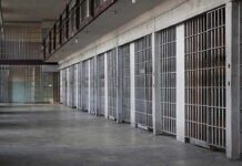 BILLION-Dollar Prison Patch Drags On prison cell block with metal barred doors