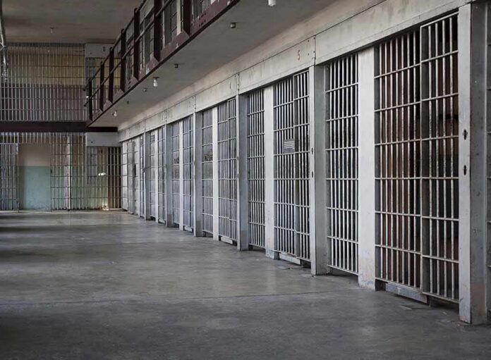 shutterstock_100994692 prison cell block with metal barred doors