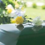 TV Star-Turned-Congressman Dies Aged 84 Yellow rose and white carnation on a green casket