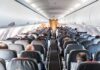Airplane cabin with passengers seated in rows
