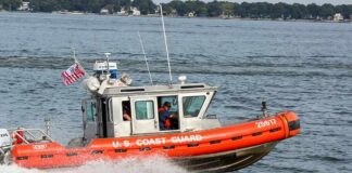 Coast Guard patrol boat speeding across a bay
